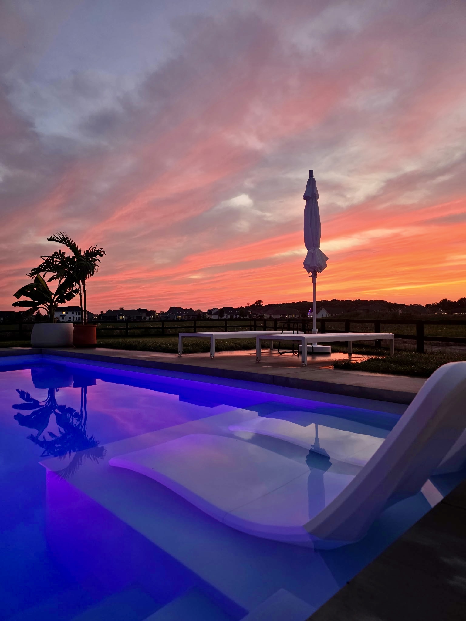 Luxury pool at sunset with glowing blue LED lighting