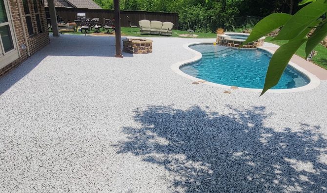 White rubber surfacing around freeform pool with fire pit